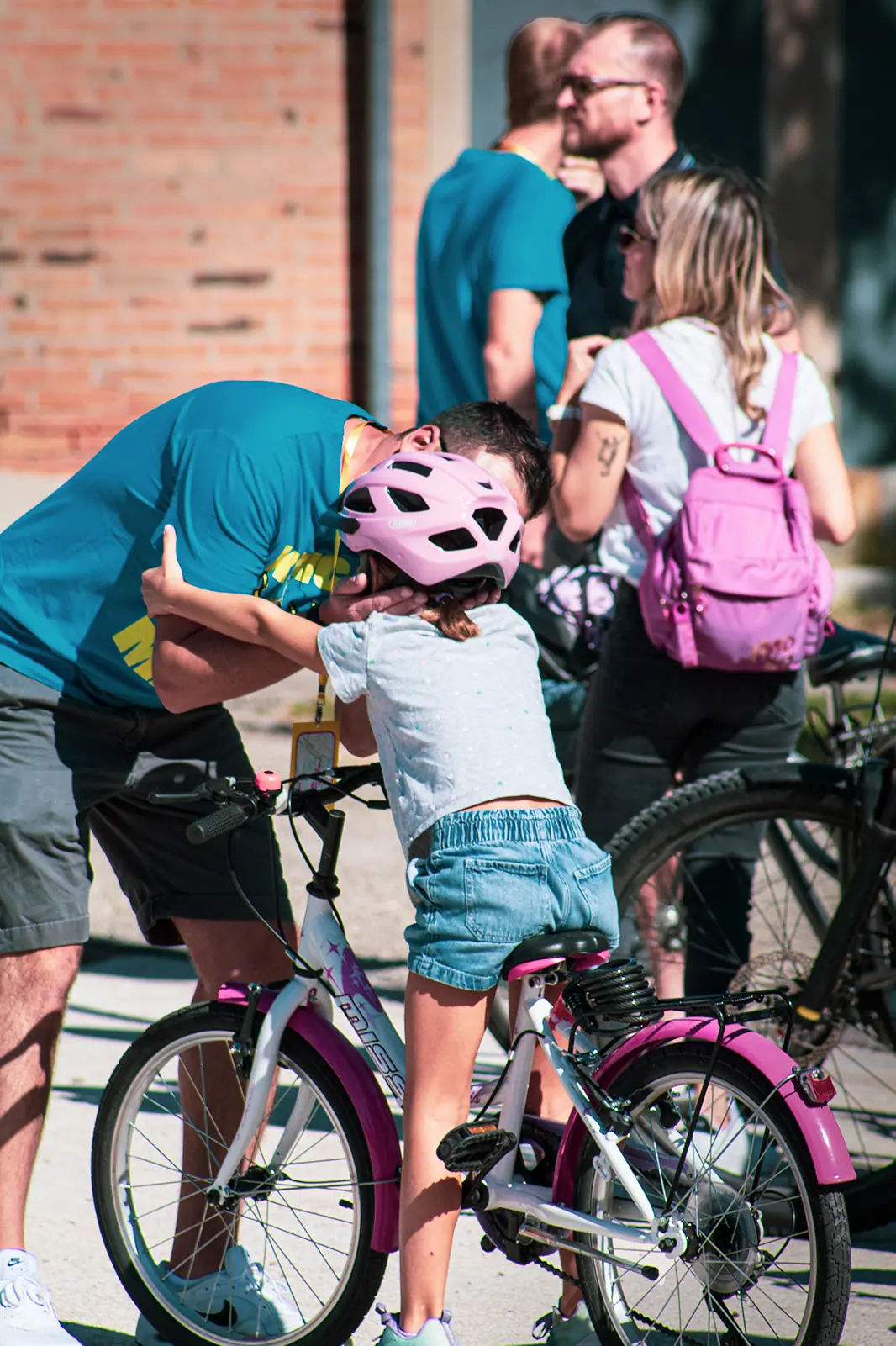 Un volontario aiuta una bambina con il casco
