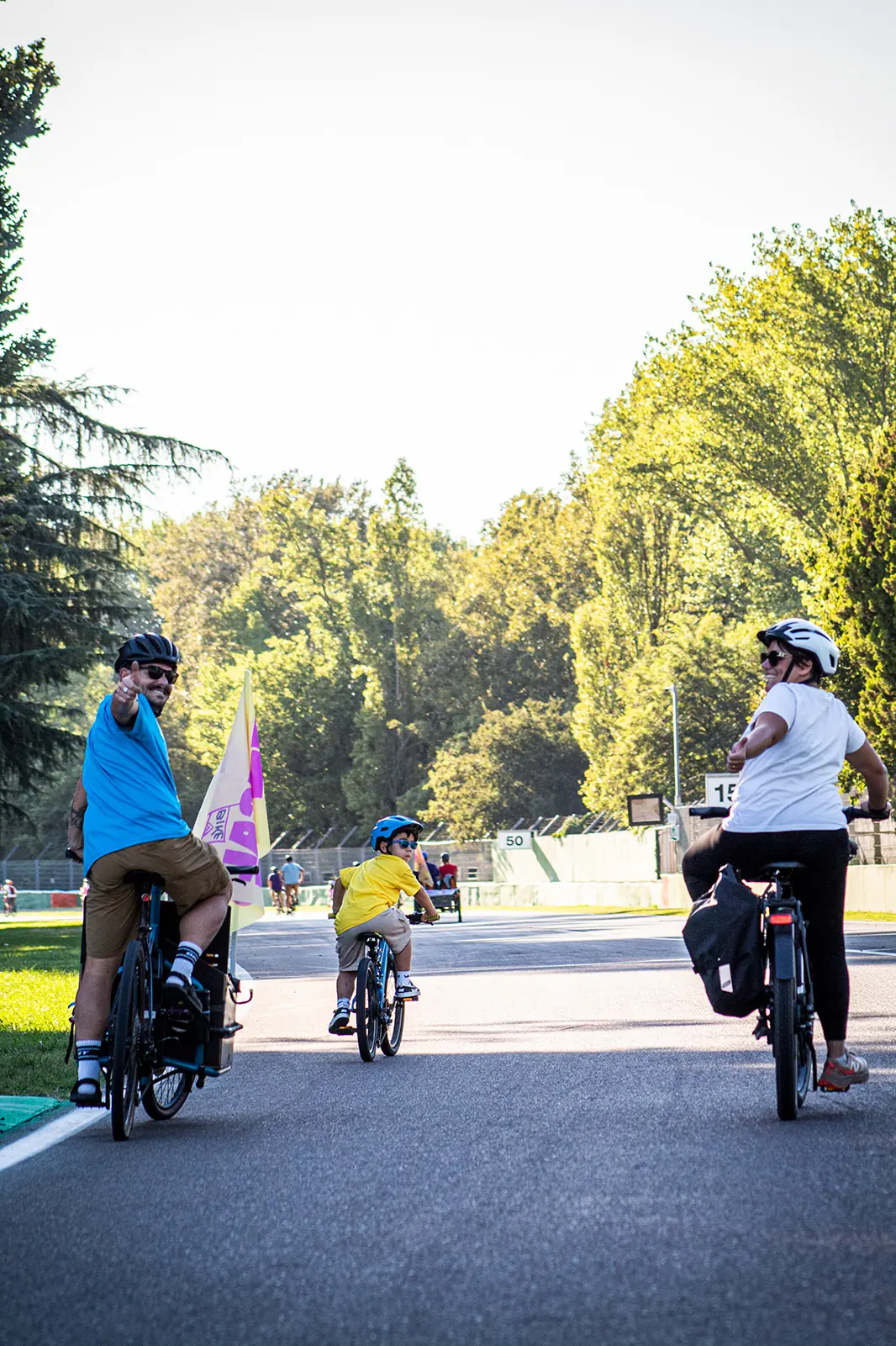 Famiglia in bici sulla pista dell'Autodromo saluta