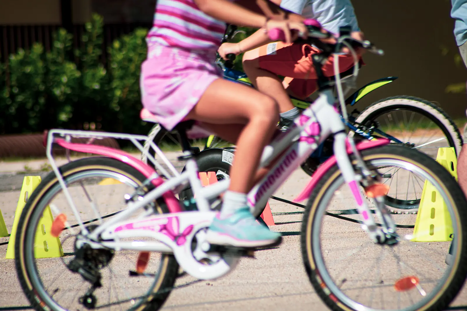 Bambine pedalano tra i coni del percorso