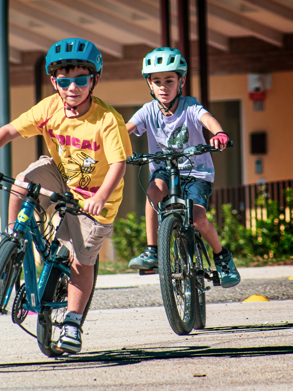 Due bambini pedalano con il casco